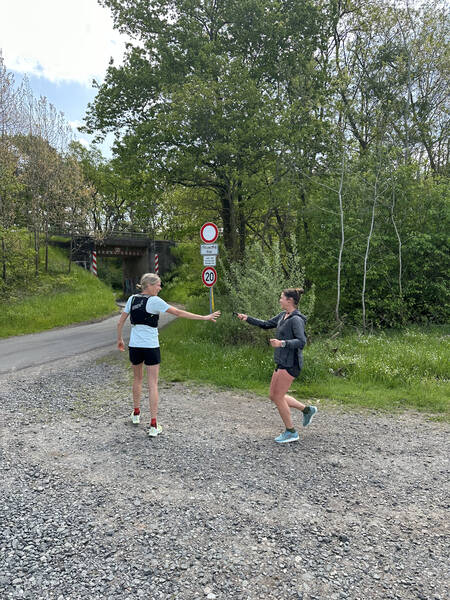 Maiken handing off the relay stick – which is our GPS watch – to Judith