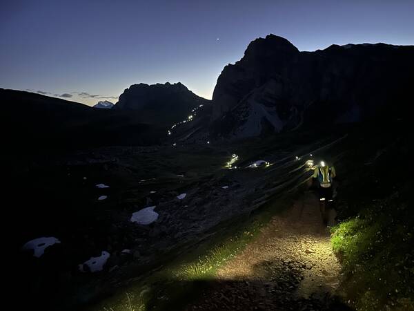 The long headlamp snake moving through the mountains behind me