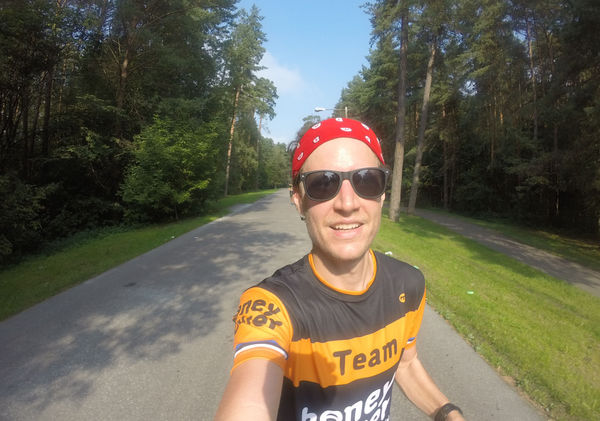 Dude running on empty forrest roads taking a photo of himself